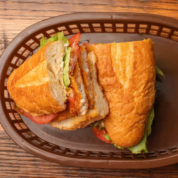 JD's Cafe southern fried chicken po'boy sandwich with lettuce and tomato in a basket.